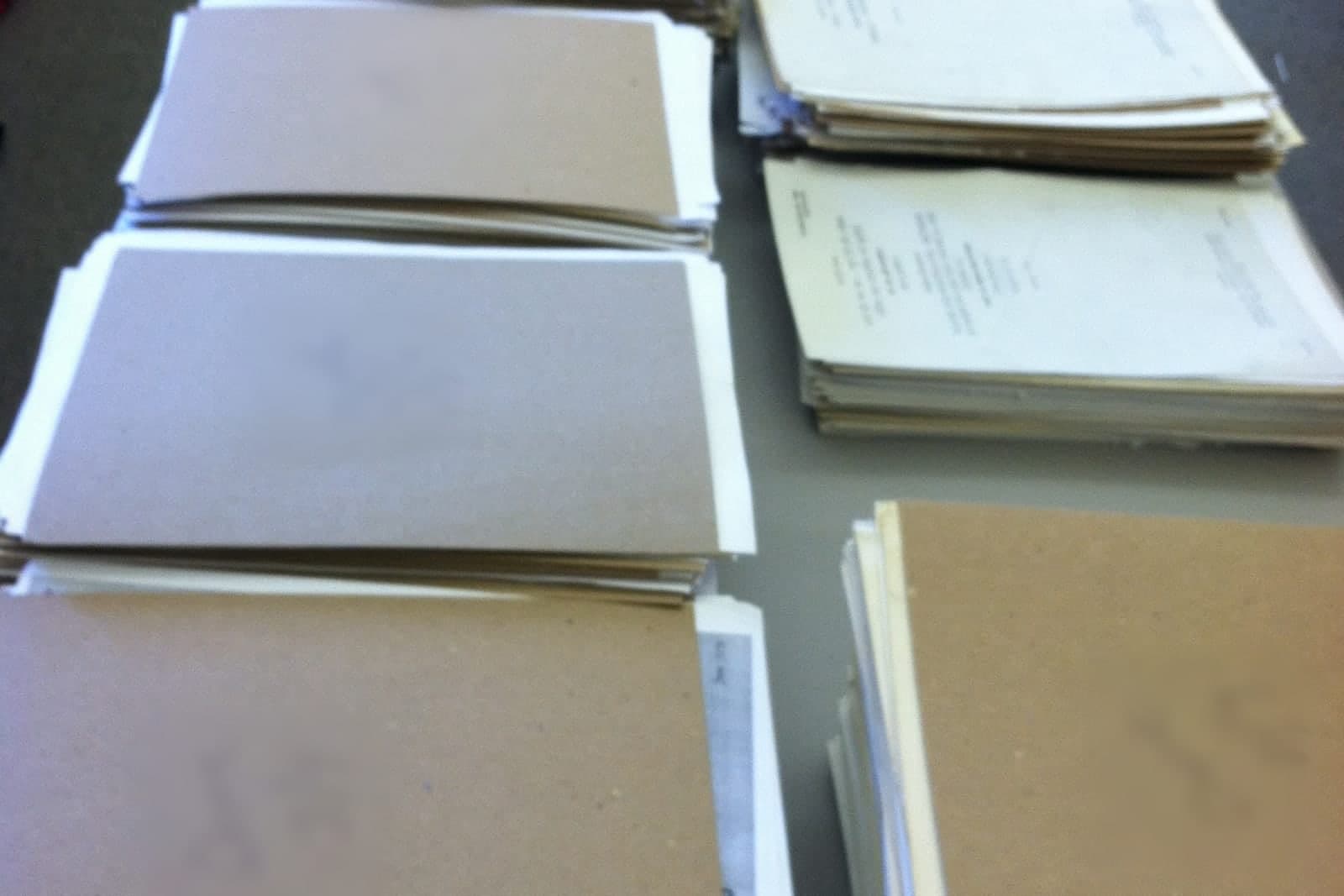 Stacks of paper documents sorted into separate piles on a table