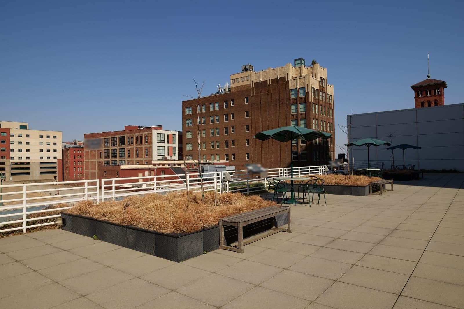 The rooftop terrace of the Kansas City Central Library looks out over downtown brick buildings under a clear blue sky in Kansas City, Missouri