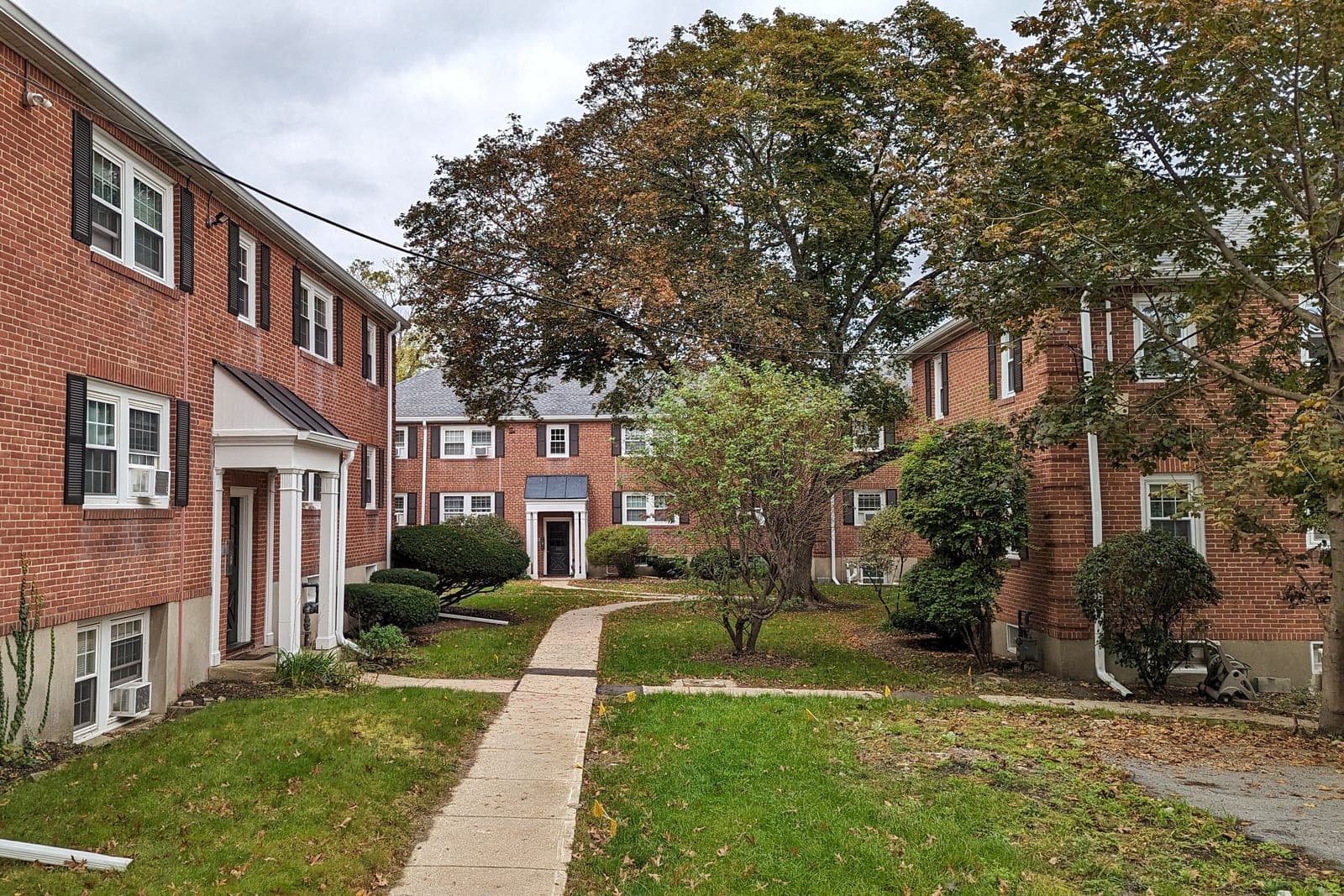 Red-brick apartment buildings set around a lawn and a walkway