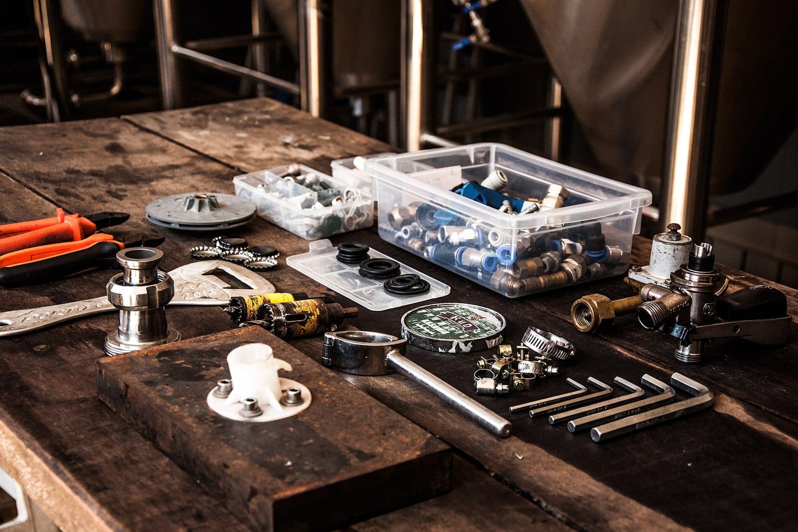 Plumbing fittings, valves and hand tools laid out on a workbench