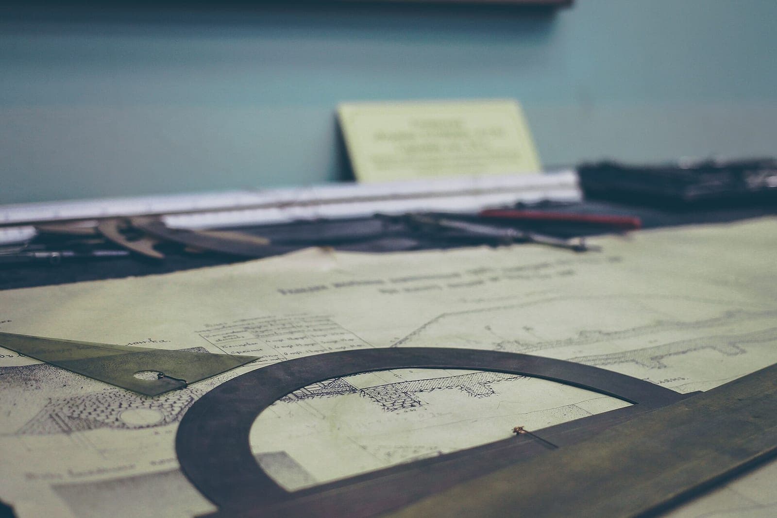 Old drawings on a desk with a protractor and a triangle ruler