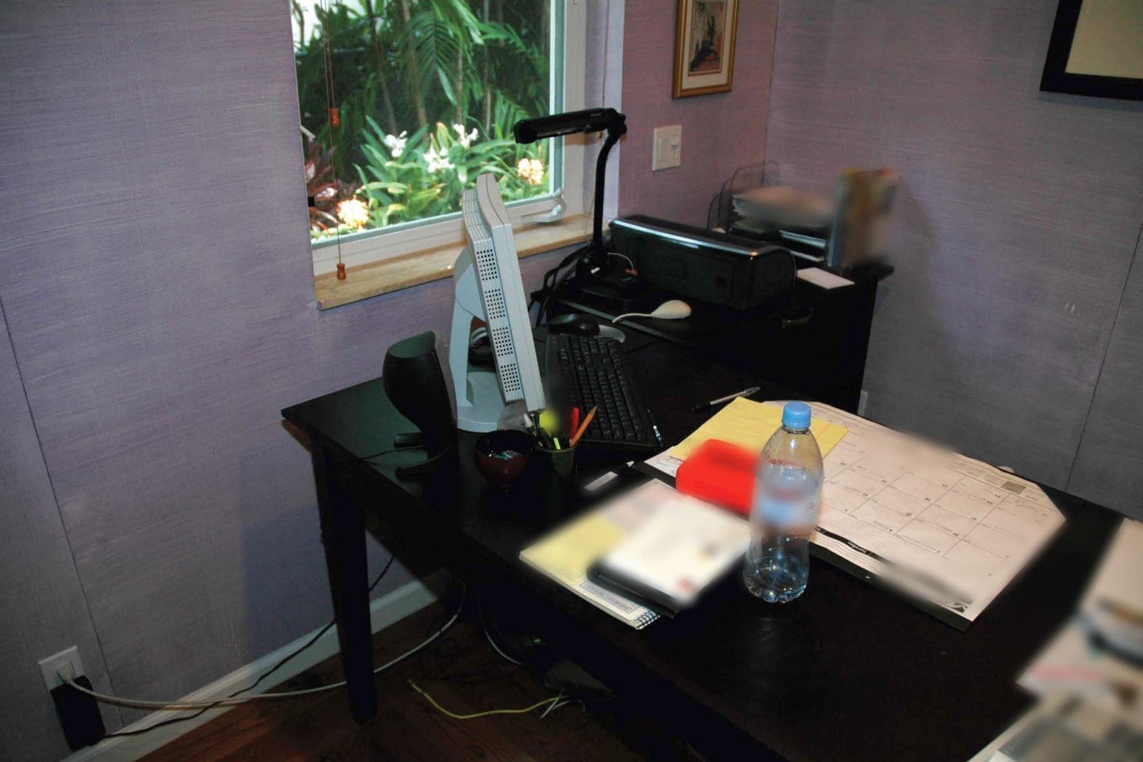 An office desk with a desk calendar, legal pads, folders, a printer and a letter tray