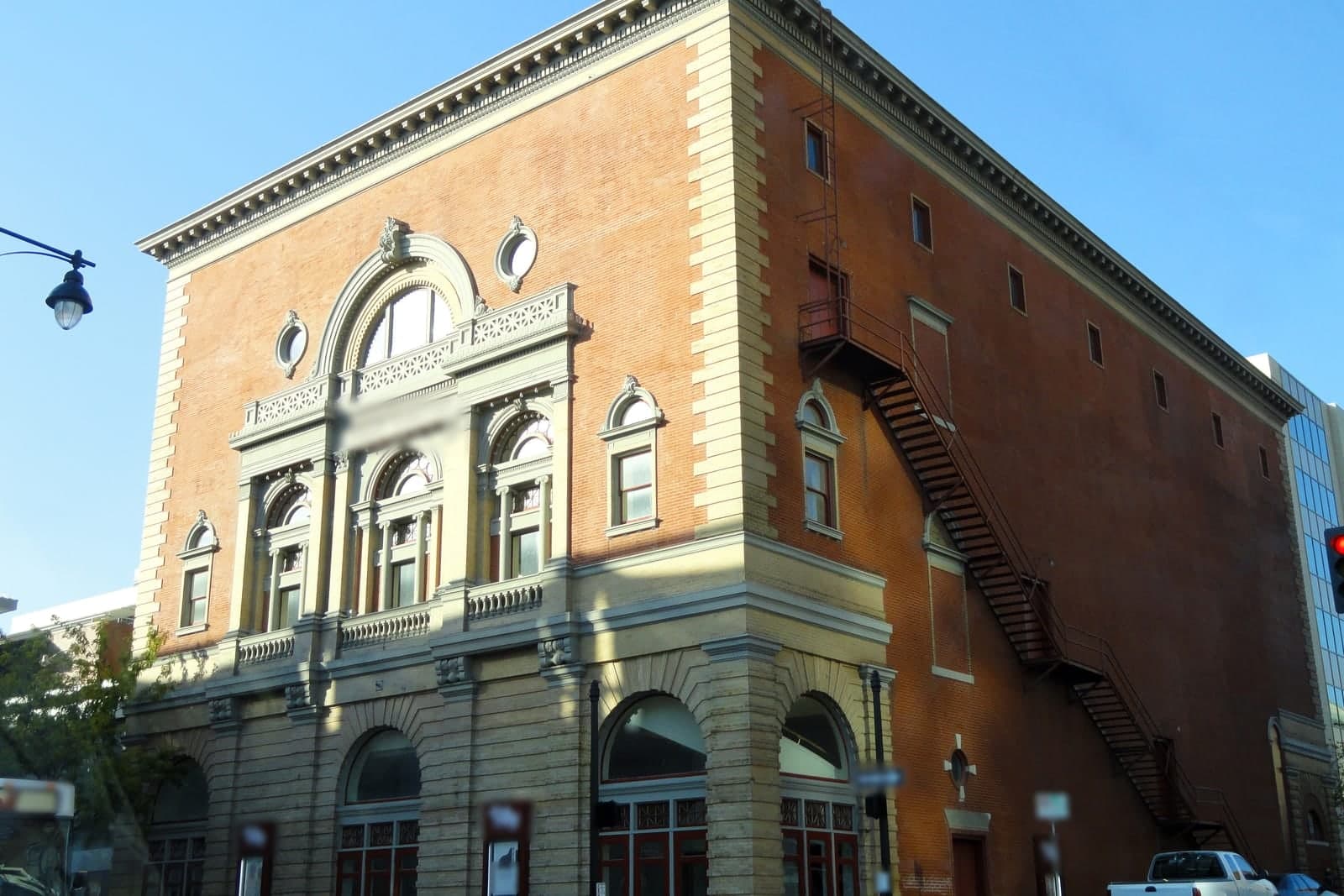 The ornate brick and stone front of the historic Folly Theater under a blue sky in downtown Kansas City, Missouri