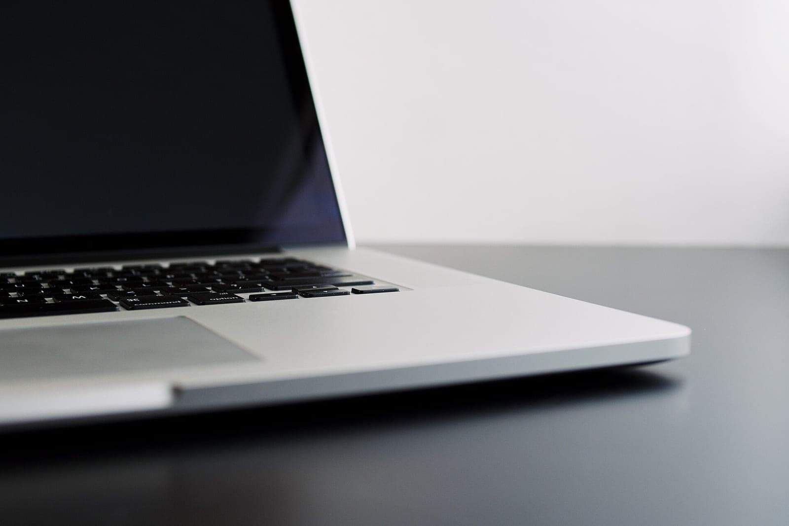 An open silver laptop on a dark gray desk