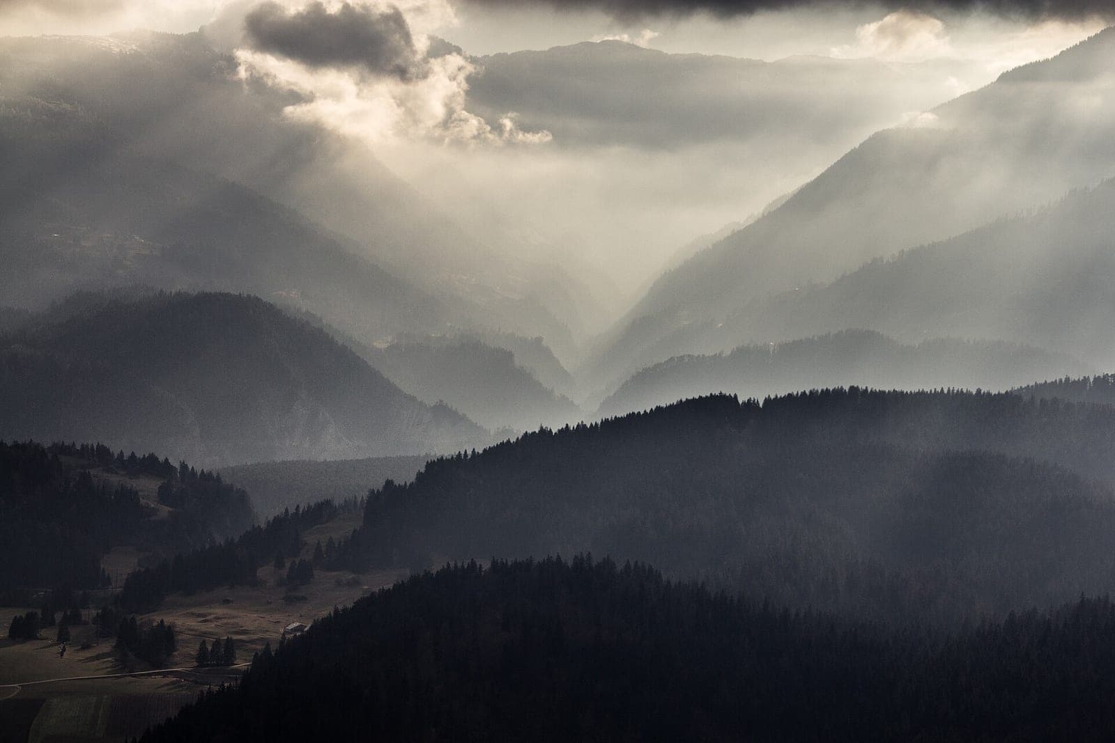 Forested mountain ridges fading into mist in layer after layer under clouds