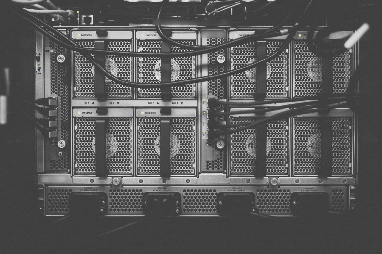 Black and white view of the back of a network server with fan panels and cables